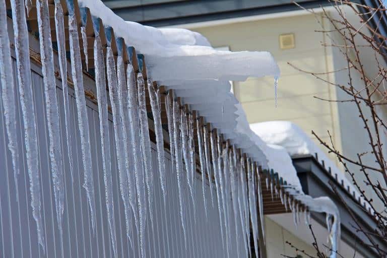 How to Remove an Ice Dam - A Picture of a Roof Edge with and Snow and Icicles