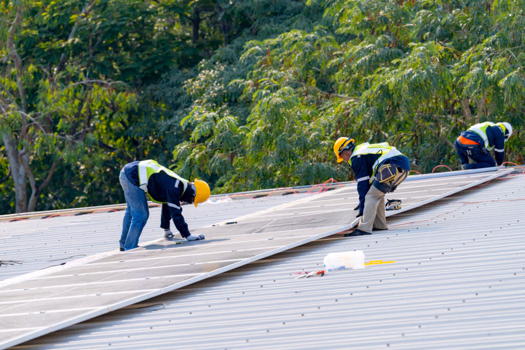 Areas We Serve - Two Roofers Working On a Commercial Roof Replacement Project in St Paul